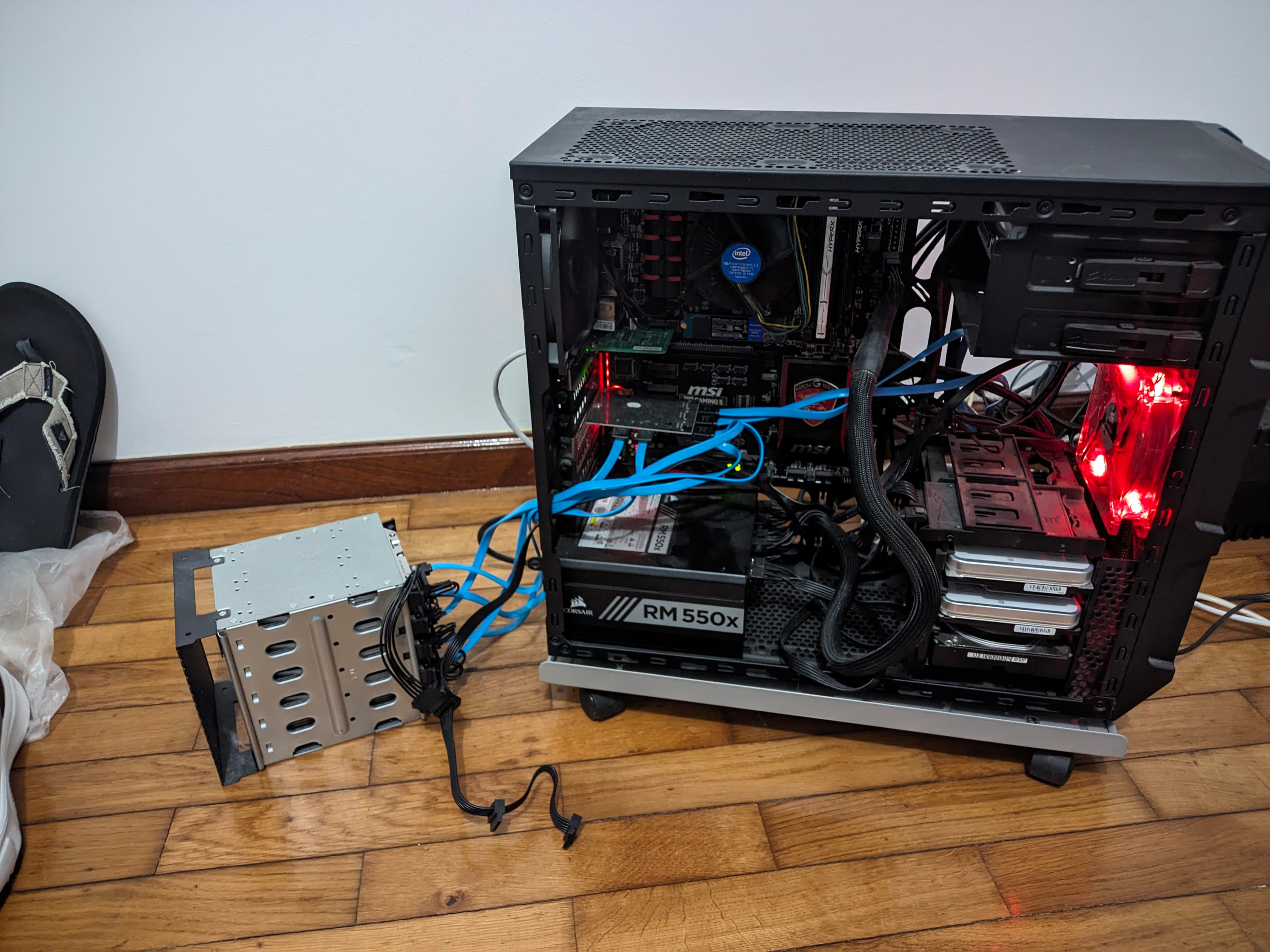 The server with its side panel off, an external drive cage wired in beside it
